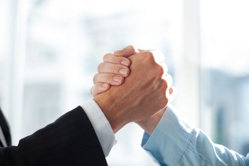 Mãos dadas em sinal de parceria entre EZ4 e Totvs Infra Services