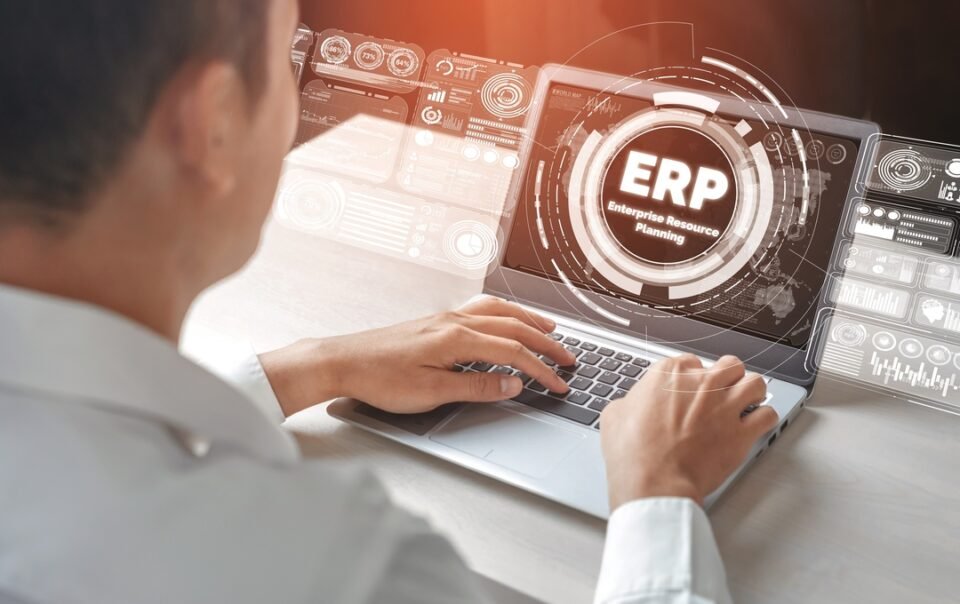 Profissional mexendo no computador enquanto realiza a implementação de um ERP.