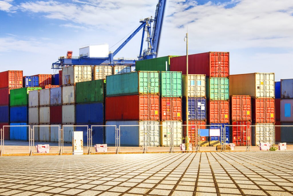 Gestão de logística internacional: containers coloridos empilhados em um terminal.